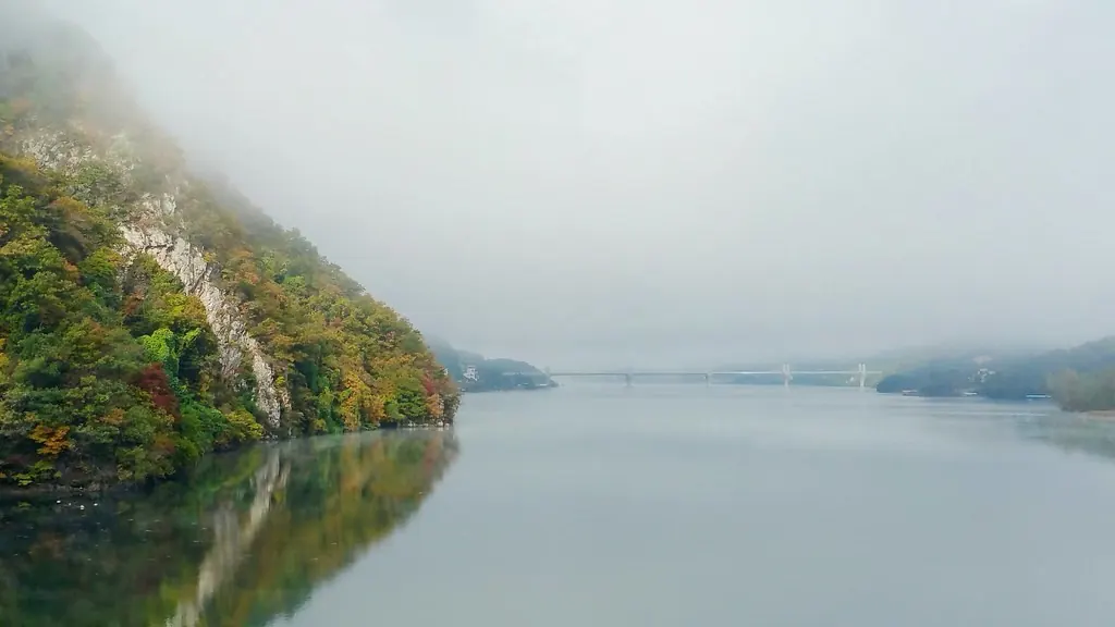 Lago en calma con niebla entre montañas