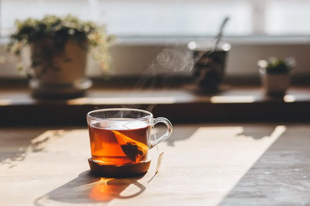 Taza de té al sol junto a una ventana